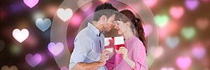 Valentines couple giving presents with love hearts background