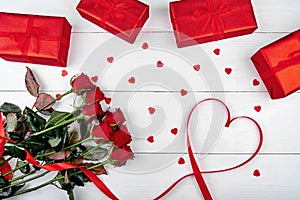 Valentines Day background with bouquet of red roses, gift boxes, ribbon shaped as heart, copy space. Greeting card mockup. Love