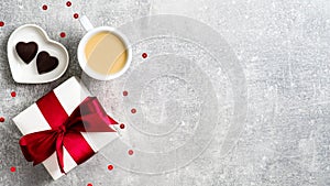 Valentines Day background with coffee cup, gift box, heart shaped candy on stone table. Flat lay style composition, top view. Love