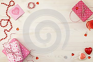 Valentines Day background with gift boxes, red ball string, different hearts and candle on a light wooden background