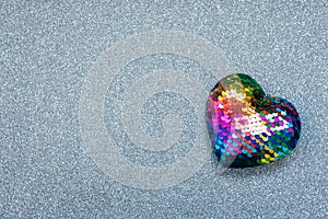 Valentines Day background, mockup with one Lgbt rainbow heart on silver shiny glitter background. Valentine Day, love, romance,