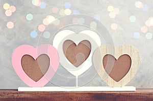 Valentines day background, photo frame heart shape on wooden table, blurred bokeh light