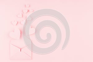 Valentines day background of pink paper envelop and stream soar small hearts on pink paper background. Copy space.