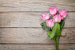 Valentines day background with pink roses over wooden table