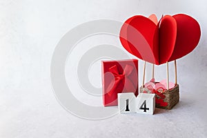 Valentines day background with red heart parachute, gift box on white background, copy space