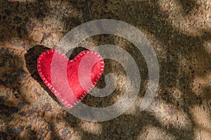 Valentines day background, red heart on rusty background with sunbeams with copy space