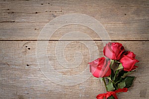 Día de San Valentín rosa roja a cinta sobre el de madera 