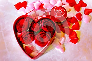 Valentines Day background. Red Roses with hearts and candle on pink background