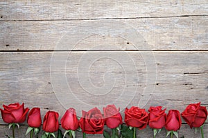 Valentines day background with red roses on wooden.