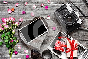 Valentines day background. retro camera and blank photo frame in heart shaped film