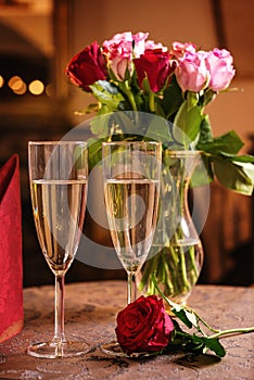 Valentines day background with roses and champagne in hotel or restaurant, romantic evening