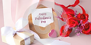 Valentines day background with white card and kraft envelope, rose and gift box