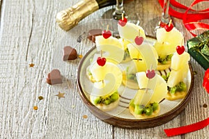 Valentines day or birthday romantic antipasto. Canapes with cheese, kiwi and pineapple.