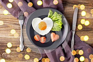 Valentines day breakfast with heart shaped fried eggs served on grey plate