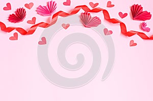 Valentines Day card, red ribbon and paper hearts on a pink background