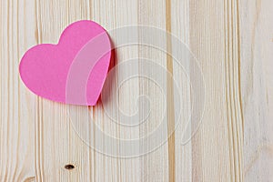 Valentines day card with sticky note in the shape of a heart on a wooden background