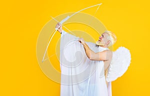 Valentines Day celebration. Cupid man in white angel wings with bow and arrow. God of love. Valentines day cupid angel