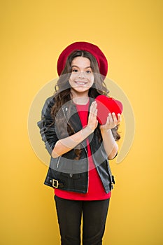 Valentines day. child on yellow backdrop. small girl kid with long curly hair. happy girl in beret leather jacket