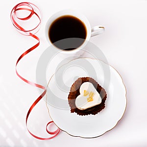 Valentines day composition with coffee cup and heart shape cake on white table. Top view. Copy space.