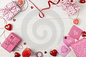 Valentines Day composition with gift boxes and different hearts on a light wooden background