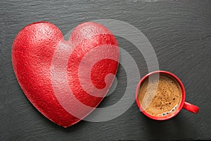 Valentines day composition with red coffee cup and big heart of red velvet cake over slate plate. Top view. Copy space.
