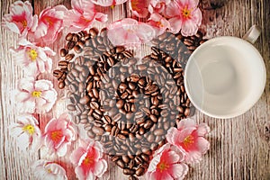 Valentines day concept: Coffee beans arranged in Heart Shape on wooden background