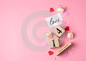 Valentines Day concept. February 14 wooden calendar, greeting card with the inscription love, pink and red hearts