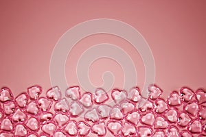 Valentines Day Concept. Glass transparent hearts on pink background, glass heart glows, glass painting. Many red glass hearts.