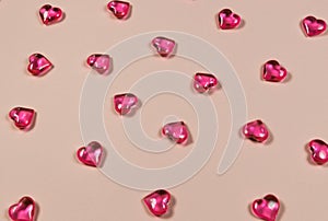 Valentines Day Concept. Glass transparent hearts on pink background, glass heart glows, glass painting. Many red glass