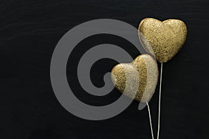 Valentines day concept. gold glitter hearts over black background. Flat lay composition