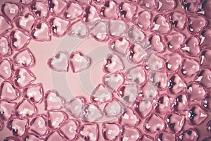 Valentines Day Concept. Two red hearts in an environment glass transparent hearts on pink background, glass heart glows, glass