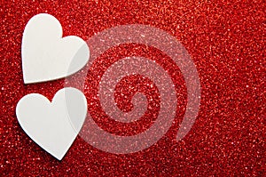 Valentines day concept. White decorative Hearts on red shiny background with copy space. Shiny sparkle metallic glitter texture.