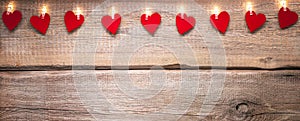 Valentines day copy space background with string lights and paper hearts on wood texture