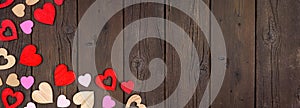 Valentines Day corner border of wooden hearts on a dark wood banner background