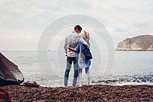 Valentines day. Couple in love enjoying honeymoon in Santorini island, Greece. People walking on beach by sea. Vacation