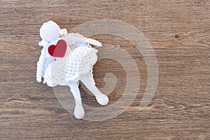 Valentines day crochet angel and two hearts on wooden table
