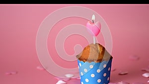 Valentines day cupcake with small pink heart on a pink background