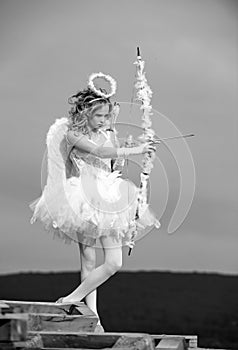 Valentines day cupid. A beautiful teen with blonde curly hair and a bow and arrow as cupid - Valentines Day. Portrait of