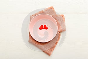 Valentines Day festive table setting on a white wooden table. Dinner meal in restaurant at Valentine Day. Two red hearts on pink