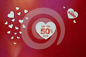 Valentines day of fifty percent sale in big white heart in the center on red background.