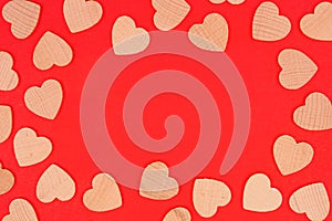 Valentines Day frame of wooden hearts on a red paper background
