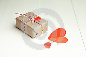 Valentines day gift box decorated with red paper hearts on white background