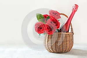 Gift hamper, bouquet of red roses, bottle of champagne on white. Valentines day card. Romantic gift photo