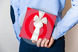 Valentines day gift,handsome Young man hiding surprise gift behing his back