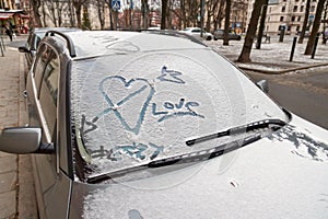 Valentines day graffiti in snow on windscreen of car