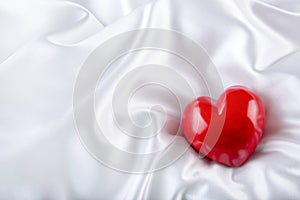 Valentines day. Hand made valentine heart. Wedding day. Red valentines hearts on white satin. Text: I love you