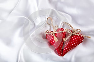 Valentines day. Hand made valentine heart. Wedding day. Red valentines hearts on white satin. Text: I love you