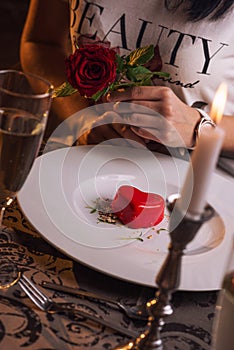 Valentines day, heart cake on white plate, romantic evening and gift, pretty woman with rose in hand.