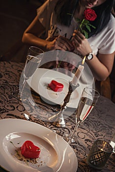 Valentines day, heart cake on white plate, romantic evening and gift, pretty woman with rose in hand.