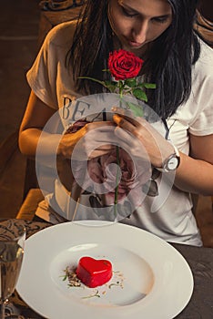 Valentines day, heart cake on white plate, romantic evening and gift, pretty woman with rose in hand.
